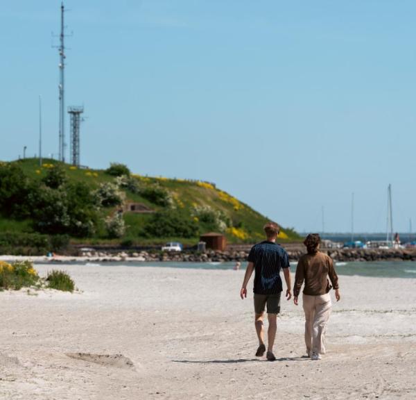 To personer går på strand