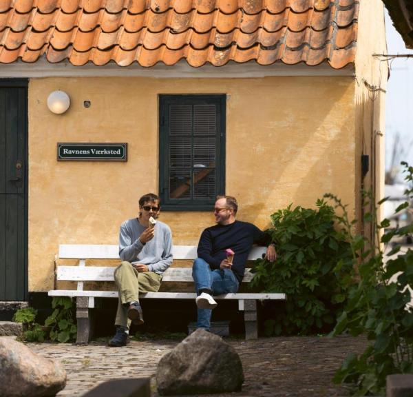 To mænd spiser is på en bænk i Dragør Gamle By
