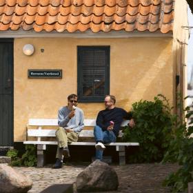 To mænd spiser is på en bænk i Dragør Gamle By